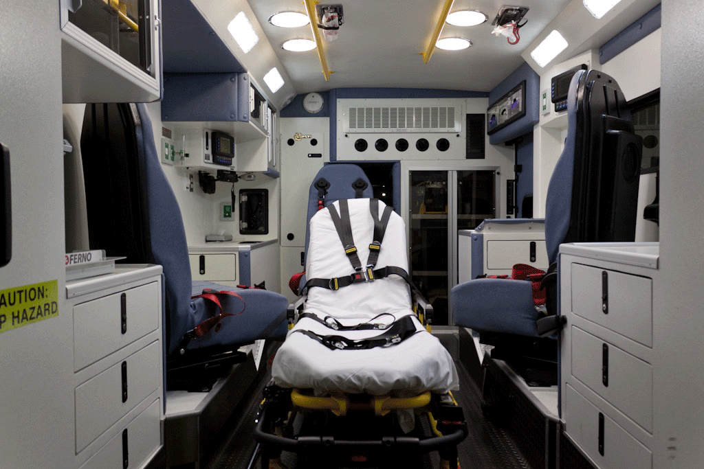 patient compartment of ambulance without squad bench; three swivel seats with seatbelts and patient stretcher