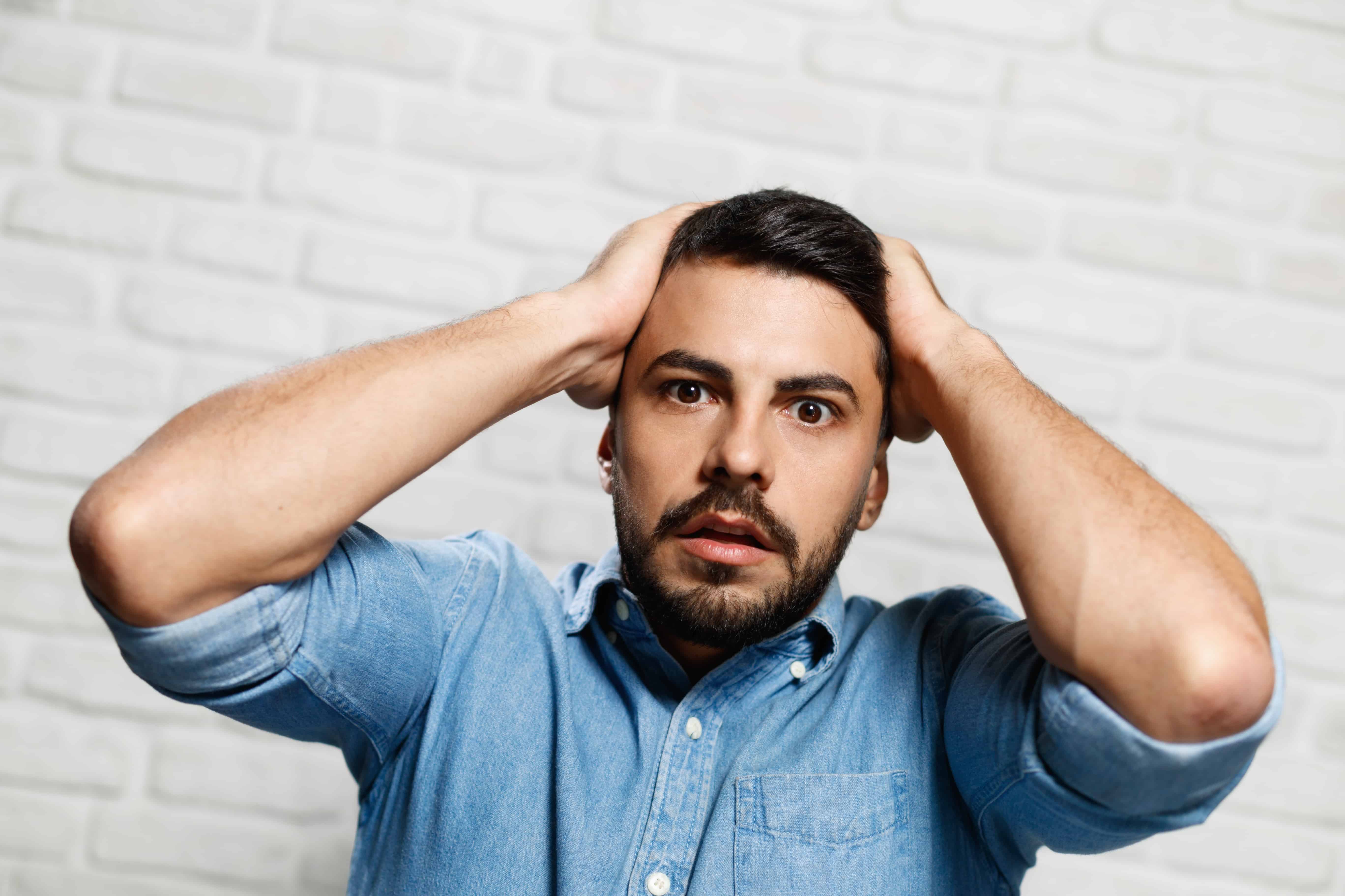 stressed young man with beard On Brick Wall