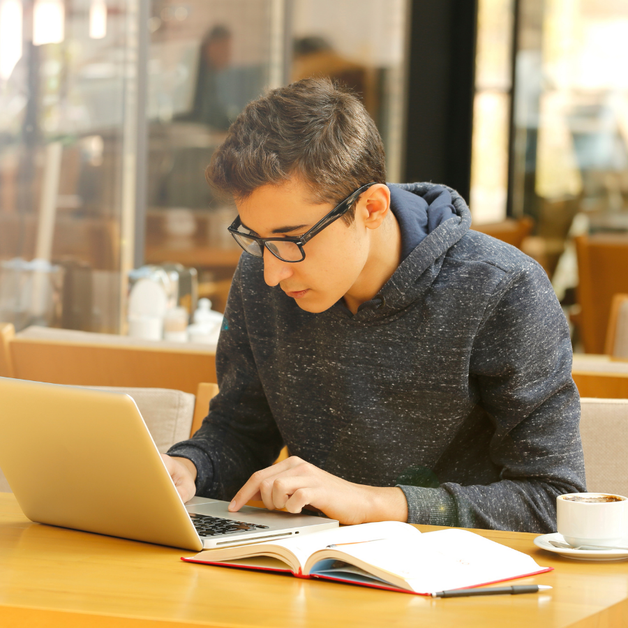 young man studying with laptop and notebook