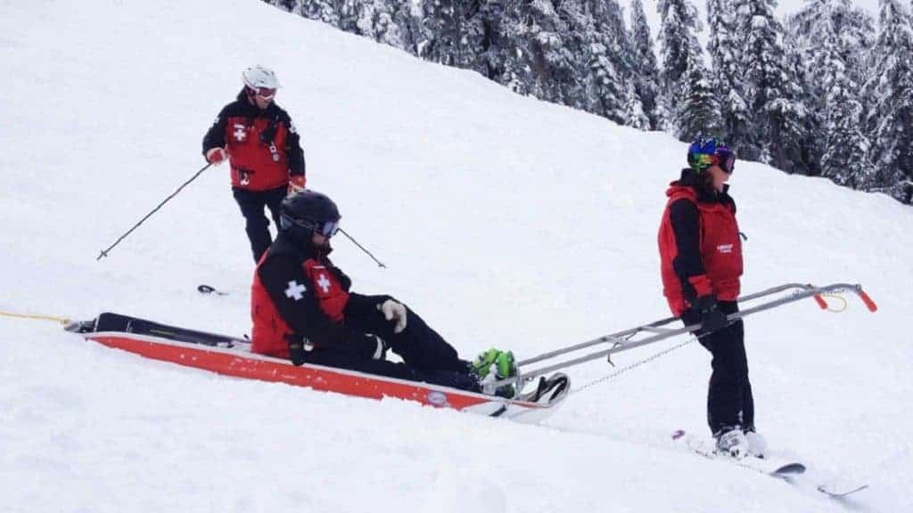 ski rescue team transporting injured skier