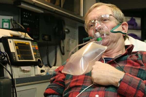 patient with glasses in non-rebreather mask in ambulance