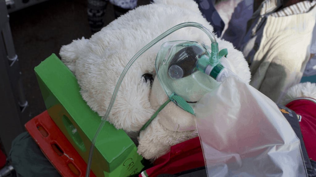 large teddy bear wearing non-rebreather mask
