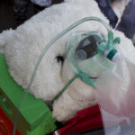 large teddy bear wearing non-rebreather mask