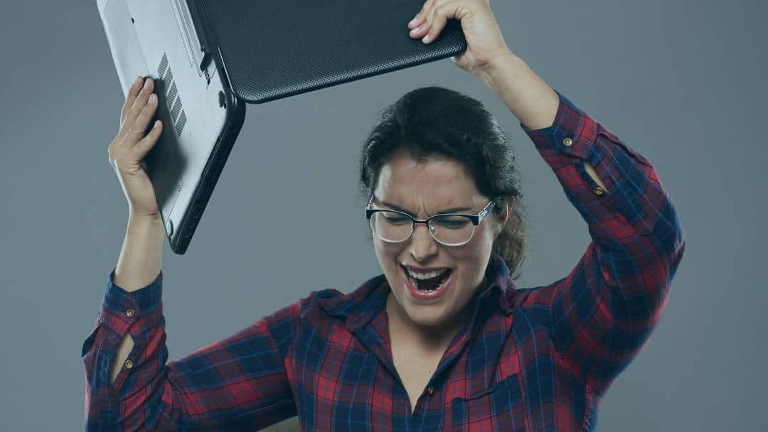 young woman angry smashing laptop