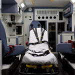 patient compartment of ambulance without squad bench; three swivel seats with seatbelts and patient stretcher