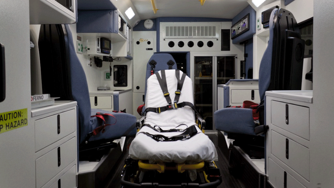 patient compartment of ambulance without squad bench; three swivel seats with seatbelts and patient stretcher