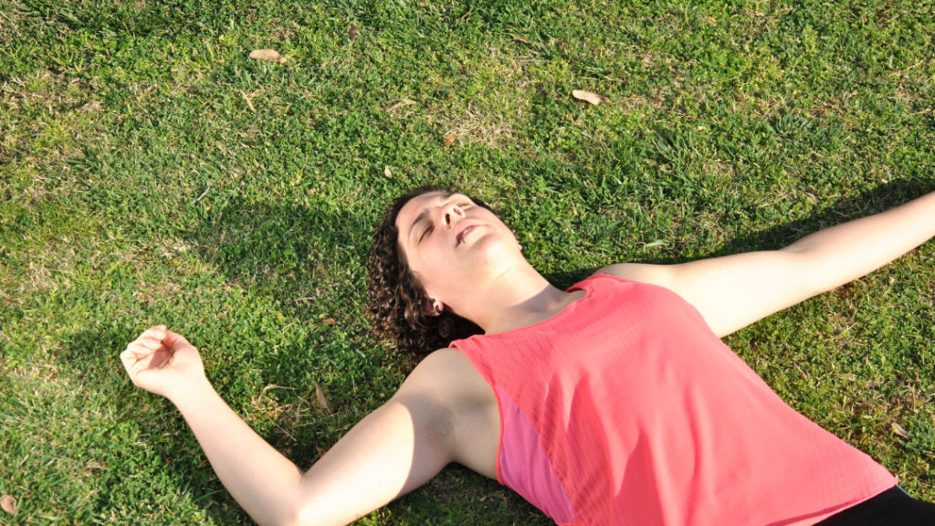 overheated woman lying on grass in sun
